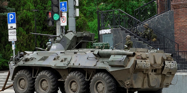 Ein gepanzerter Personentransporter parkt in Rostow, während Söldner der Wagner-Gruppe das Gebiet patrouillieren