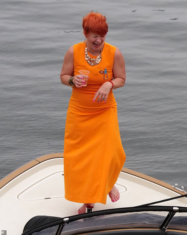 Dieser glamouröse Gast trug zu Henley ein hübsches leuchtend orangefarbenes Midikleid mit einer auffälligen goldenen Halskette