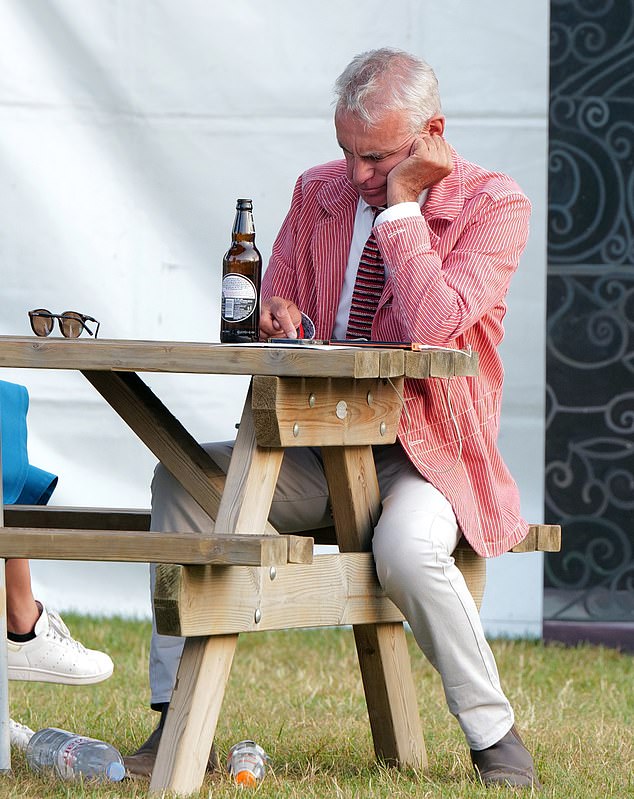 One reveller proudly wearing his rowing club's jacket scrolled on his phone while polishing off his beer