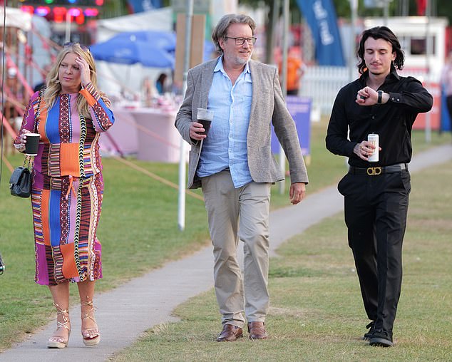 A black-clad racegoer checked his watch as he was spotted leaving Henley with friends