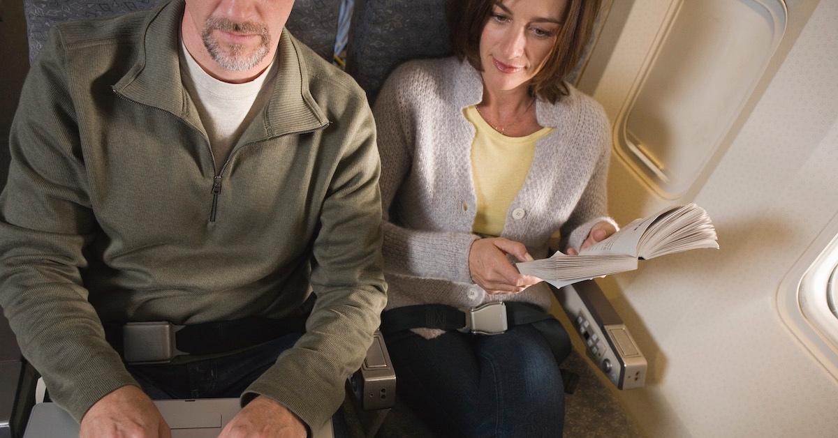 Ein Mann und eine neue Frau sitzen nebeneinander in einem Flugzeug