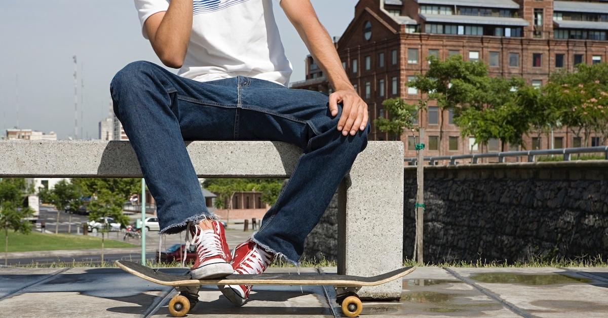 Ein Skateboarder sitzt auf einer öffentlichen Bank