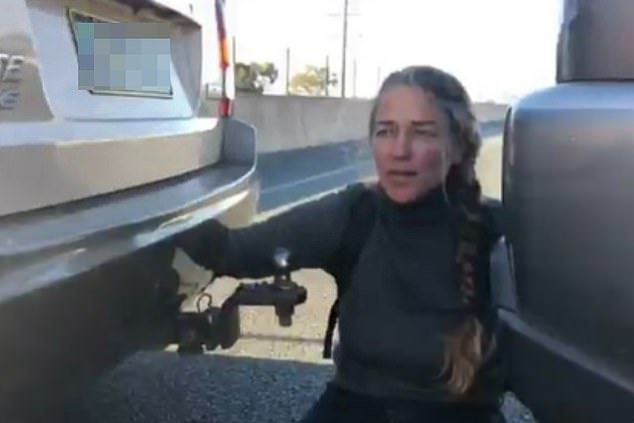 Die Blockade Australia-Demonstrantin Naomi Shine (im Bild) blockierte am Mittwoch zwei Fahrspuren, nachdem sie sich auf dem Port of Brisbane Motorway einen Kilometer östlich der Ausfahrt Pritchard Road an zwei Autos gekettet hatte