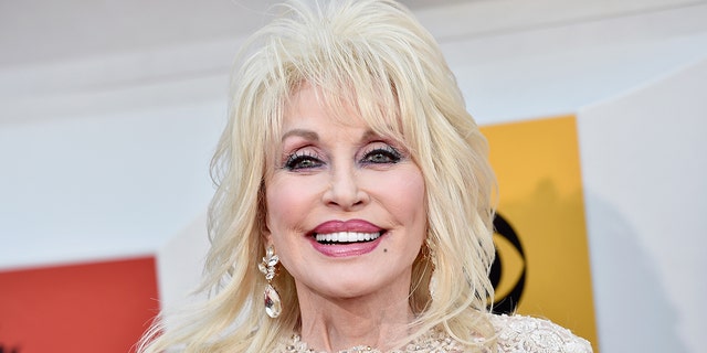 Dolly Parton lächelt bei einer Veranstaltung auf dem roten Teppich.