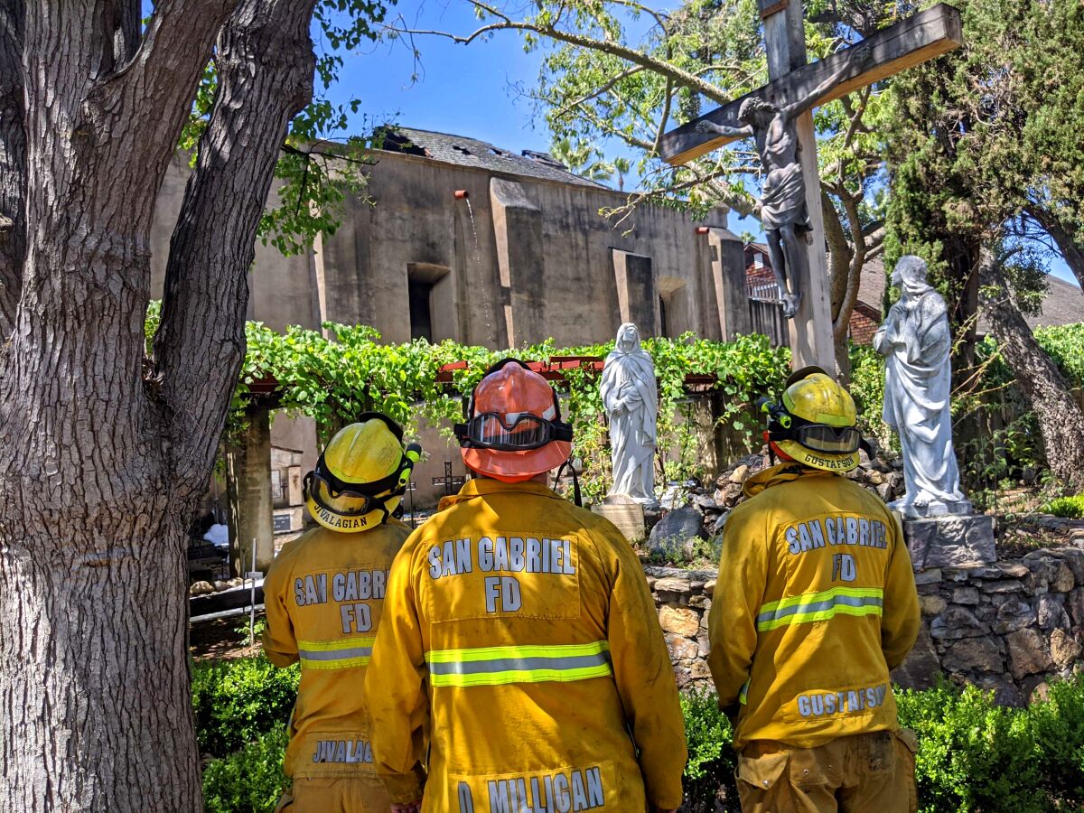 Feuerwehrleute stehen vor der San Gabriel Mission.