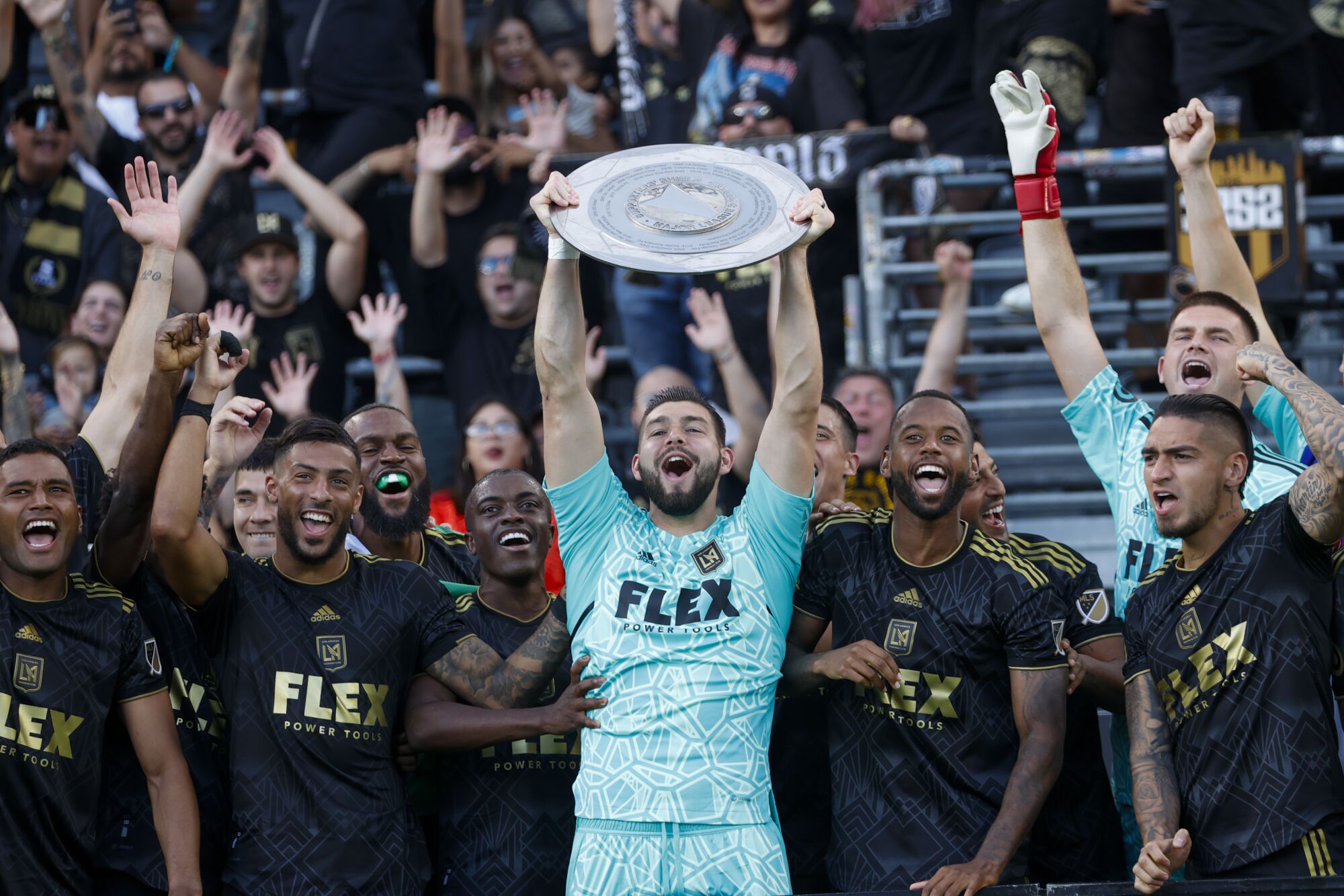LAFC-Torwart Maxime Crepeau hält die Supporters' Shield-Trophäe hoch und lächelt, während er mit seinen Teamkollegen feiert
