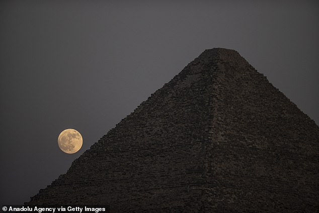 Man kann sehen, wie der Mond hinter den berühmten Pyramiden von Gizeh in Ägypten kriecht