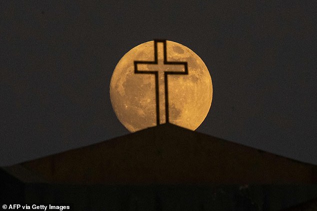 Der Mond nähert sich dem Ende seiner zunehmenden Mondphase, als er über der Chaldäischen Kathedrale der Jungfrau Maria in der irakischen Stadt Basra aufgeht