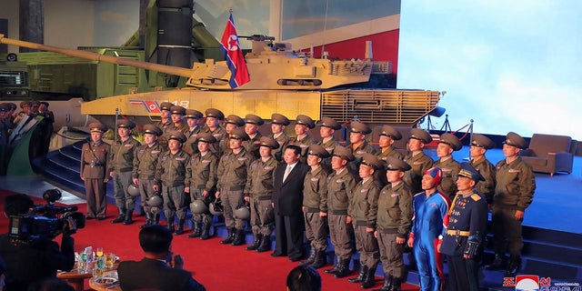 Der nordkoreanische Staatschef Kim Jong Un (Mitte) posiert am Montag für ein Gruppenfoto mit Kampfpiloten, die den Demonstrationsflug bei der Eröffnung einer Waffensystemausstellung in Pjöngjang, Nordkorea, durchgeführt haben.  (Korean Central News Agency/Korea News Service über AP)