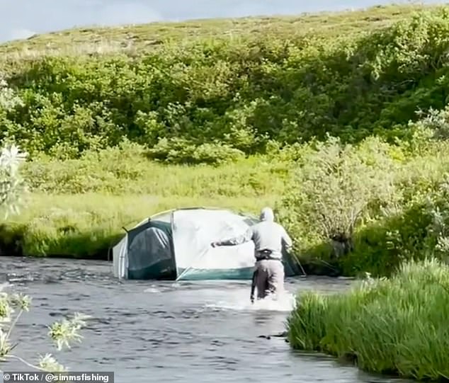 Einer der extremeren Camping-Misserfolge, gepostet von @simmsfishing, zeigt ein Zelt, das flussabwärts schwimmt, und ein Mann, der versucht, ihm nachzujagen