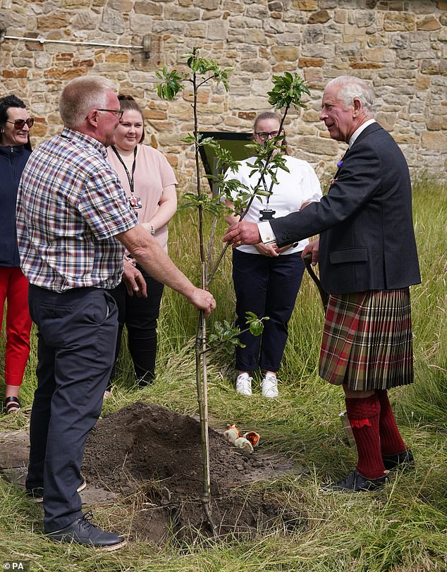 King Charles III (right) plants a tree to commemorate the centenary of the estate becoming a public park during his visit to Kinneil House