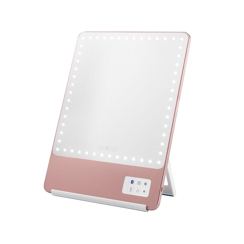 Der rosa beleuchtete Riki Loves Riki 5X-Spiegel auf weißem Hintergrund