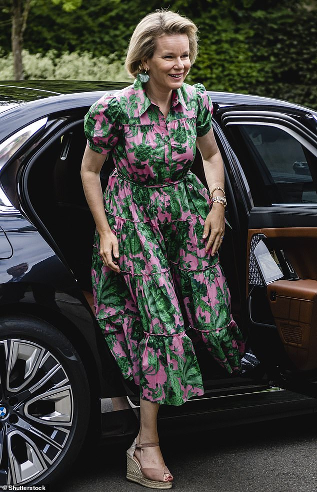 Die Königin sah elegant aus, als sie ein rosafarbenes Rüschenkleid mit waldgrünen Blumenmustern anzog