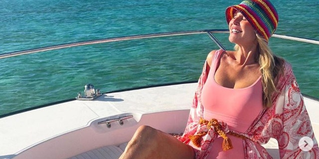 Christie Brinkley wearing a pink bathing suit on a boat
