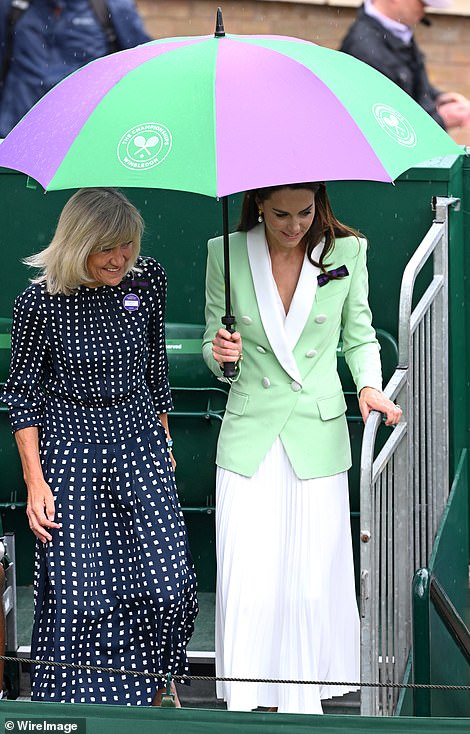 Despite rain calling off play, Kate was in high spirits and beamed as she shared an umbrella with Deborah