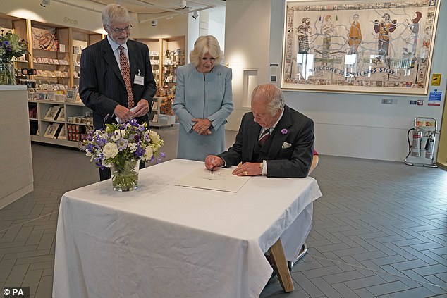 Die Königin sah zu, wie sich der König anlässlich seines heutigen Besuchs pflichtbewusst in das Gästebuch des Besucherzentrums eintrug