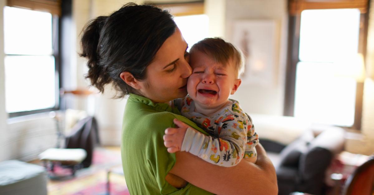 Eine Mutter hält ihren weinenden Sohn.