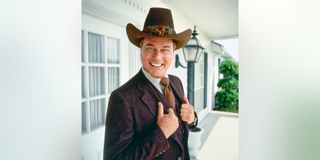 Larry Hagman verkleidet als JR auf einem lächelnden Foto