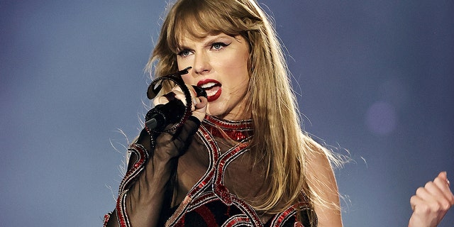 Taylor Swift singt in ihrem Overall aus der „Reputation“-Ära auf der Bühne der Era's Tour in ein Mikrofon