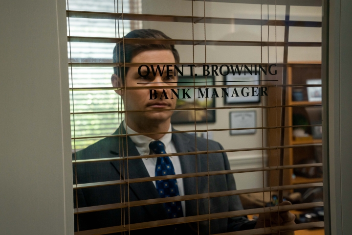 Adam Devine schaut in „The Out-Laws“ durch das Fenster seiner Bank.