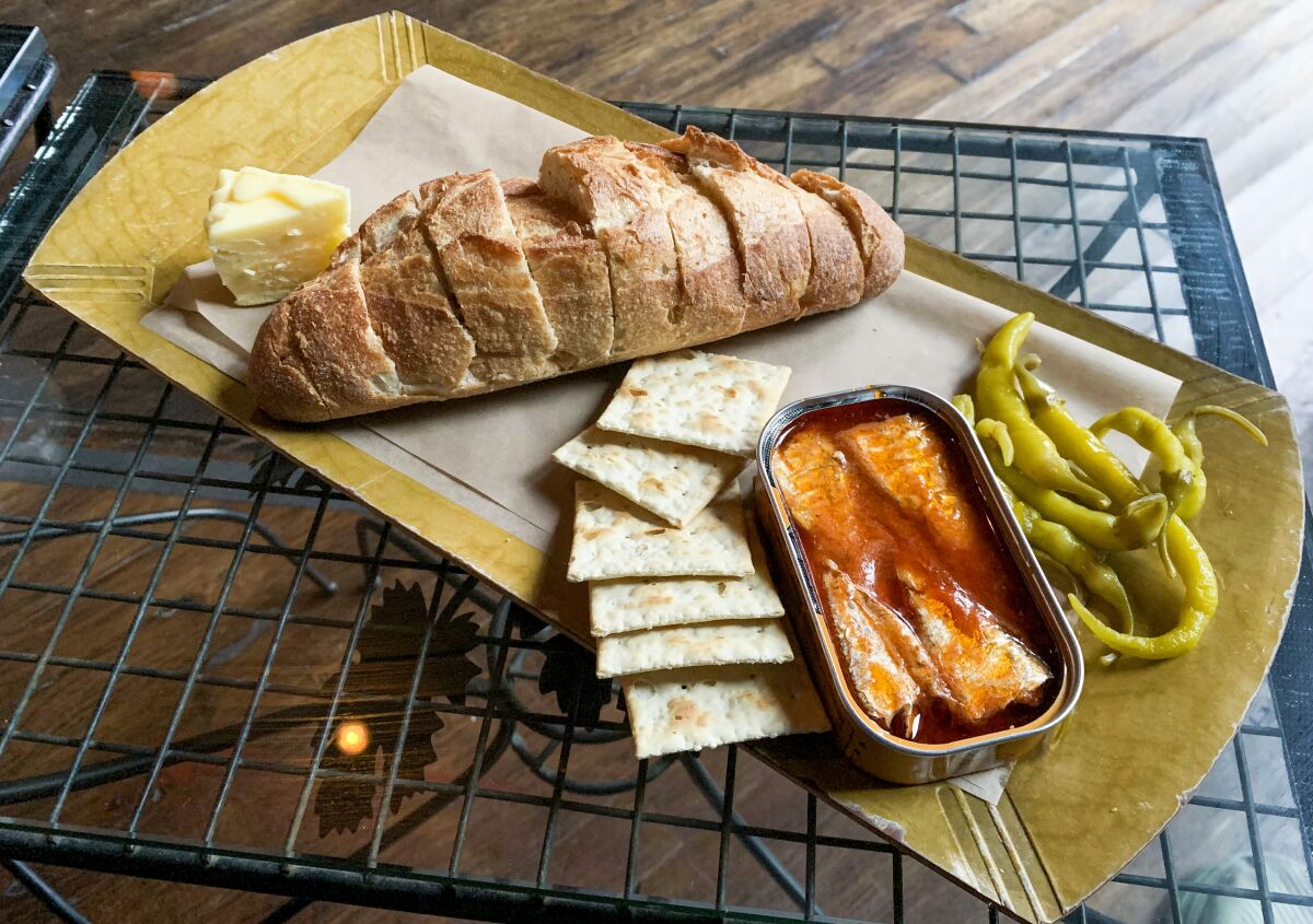 Fischkonserven und geschnittenes Brot auf einer Platte mit Crackern bei Kippered.