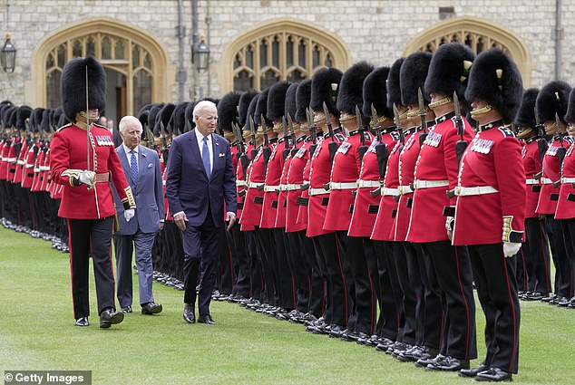 President Biden walks in front of the King as they inspect the Welsh Guards at Windsor Castle