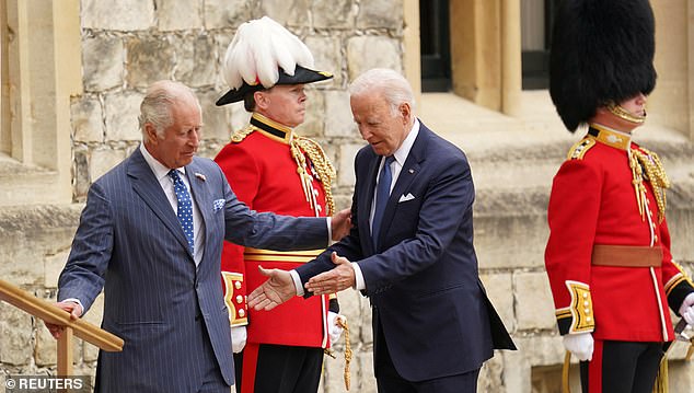 Mr Biden grabbed Charles' arm as they greeted each other on the grounds of Windsor Castle