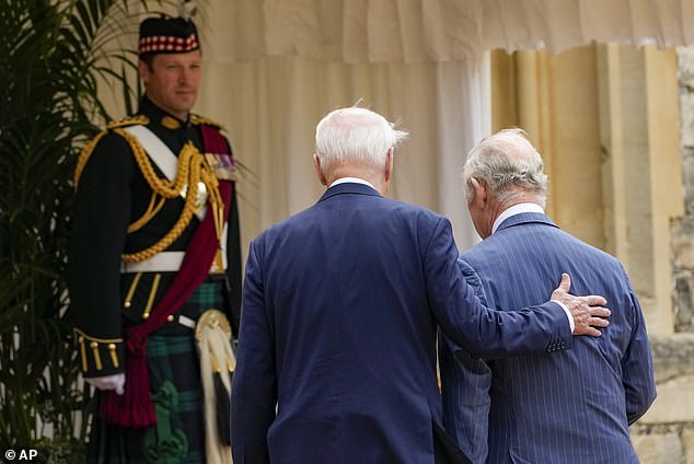 A tactile president rests his hands on Charles' back during their meeting at Windsor Castle on Monday