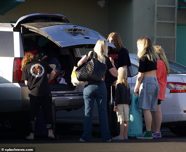 On-the-go: The family were seen loading their belongings into the back of a silver SUV after their stay at the motel