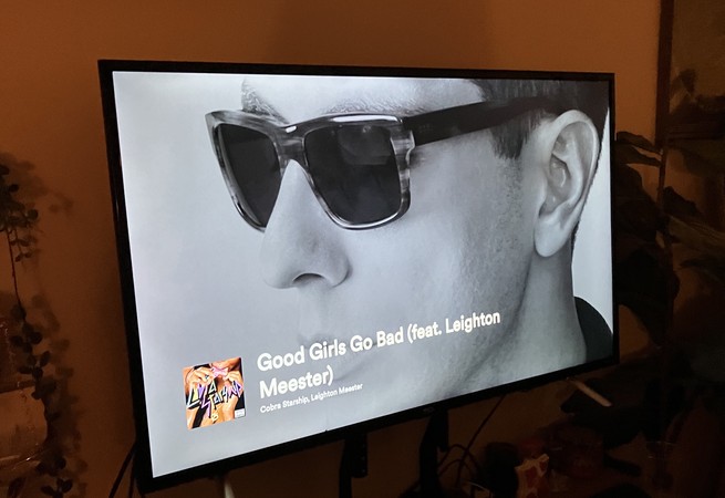 Ein Fernsehbildschirm, auf dem die Spotify-Grafik für Cobra Starship zu sehen ist "Gute Mädchen gehen schlecht."