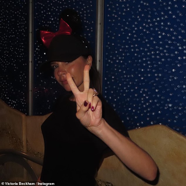 Spaß: Victoria, 49, kam in Stimmung, als sie in Disneyland ein Friedenszeichen zeigte, während sie eine rote Minnie-Maus-Schleife trug