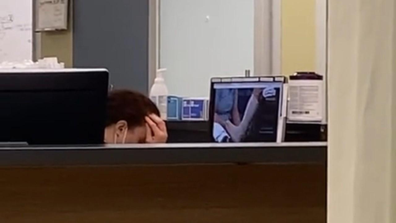 Die Ärztin sieht gestresst aus, als sie sich am Computer das Video ansieht, in dem sie den Knöchel umwickelt