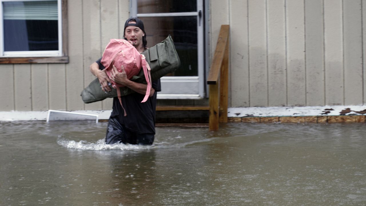 Ein Mann trägt am Montag Gegenstände aus einem Haus in Bridgewater, Vermont, durch die Fluten. 