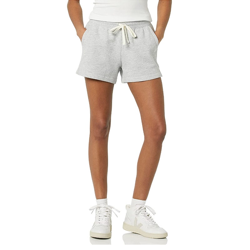 Eine Person, die die Fleece-Shorts für Damen von Amazon Essentials auf weißem Hintergrund modelliert