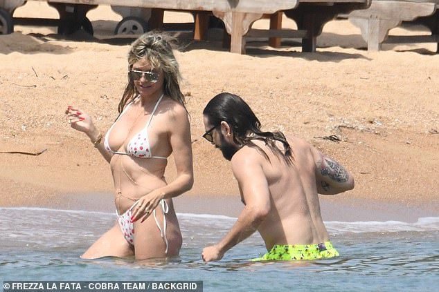 Lustige Zeiten: Tom stylte seine feuchten schulterlangen brünetten Locken direkt über seine Schultern, während er mit Heidi im Meer herumtollte