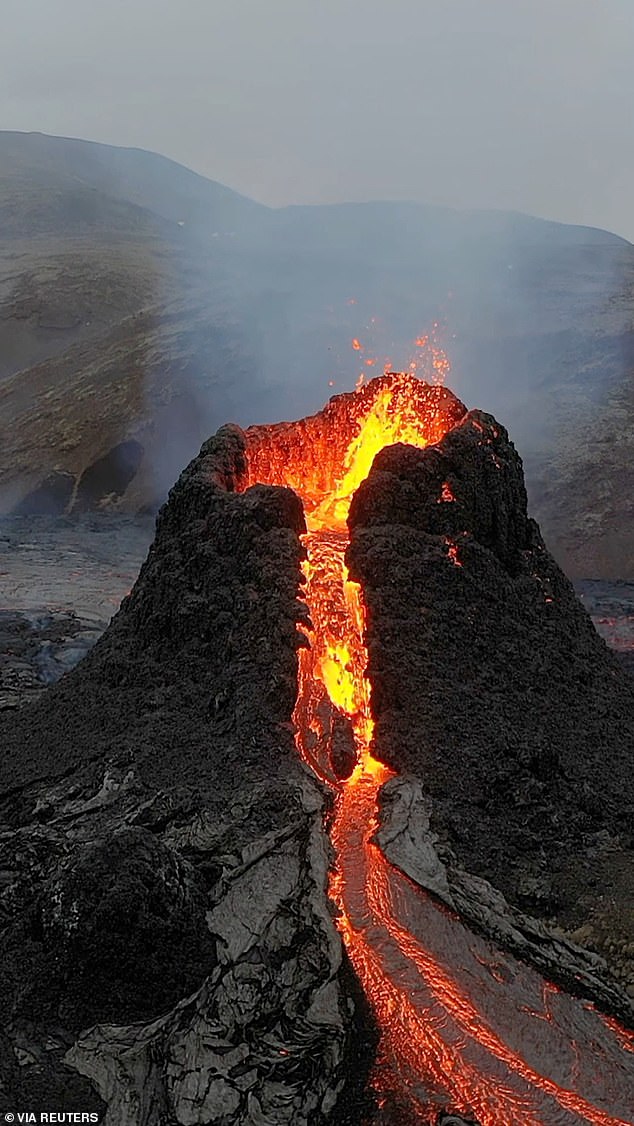Nach dem Ausbruch eines Vulkans auf der Halbinsel Reykjanes spritzt und fließt Lava bergab