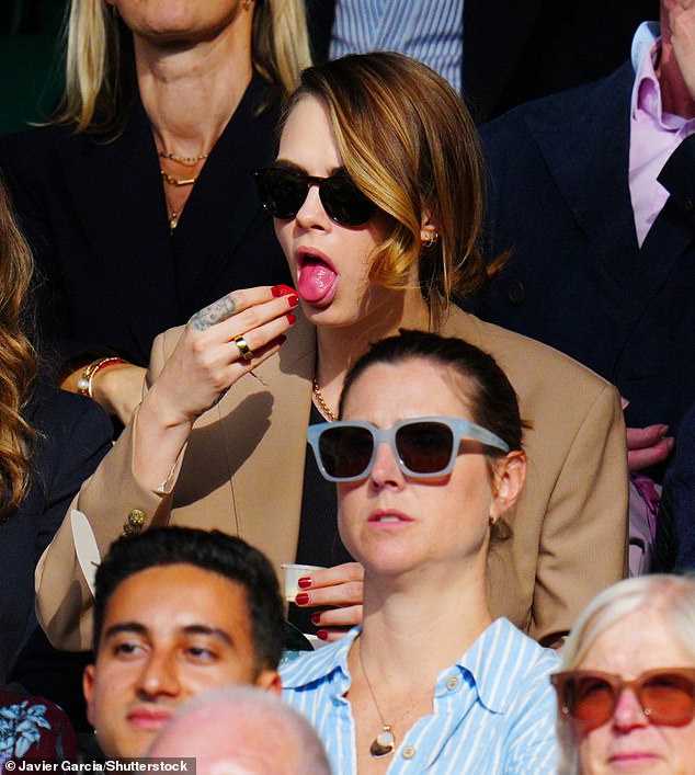 Die Schauspielerin Cara Delevigne isst am 10. Juli in Wimbledon Erdbeeren und Sahne