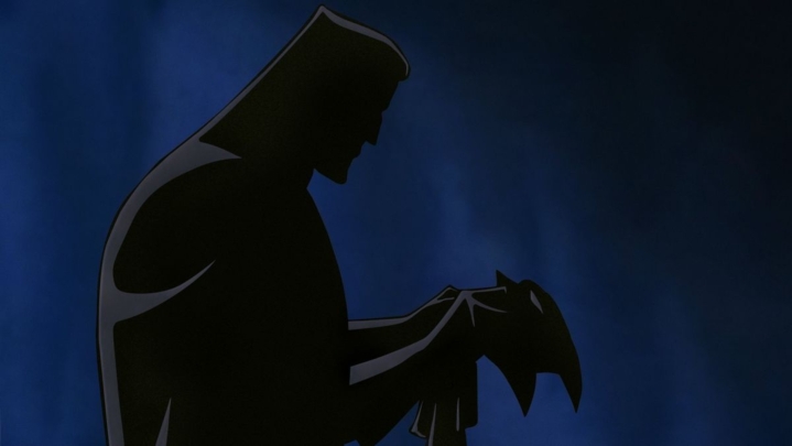 Die schattenhafte Silhouette von Bruce Wayne, der den Batman-Mantel anzieht.