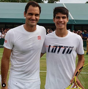 Alcaraz posing for a photo with Roger Federer