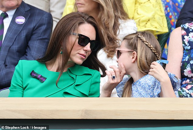A sweet moment: Princess Kate held her young daughter Charlotte's face in her hand as they sat in the Royal Box