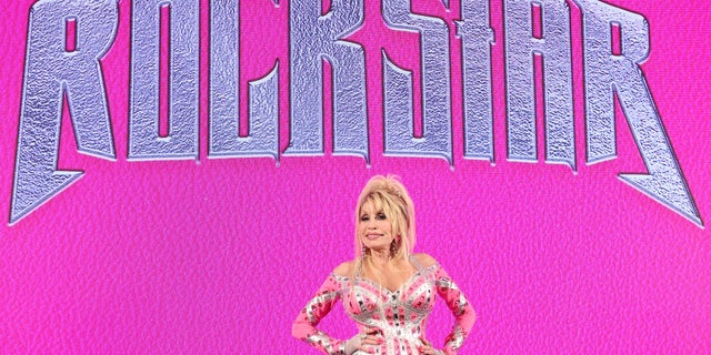 Dolly Parton vor ihrem Rockstar-Logo