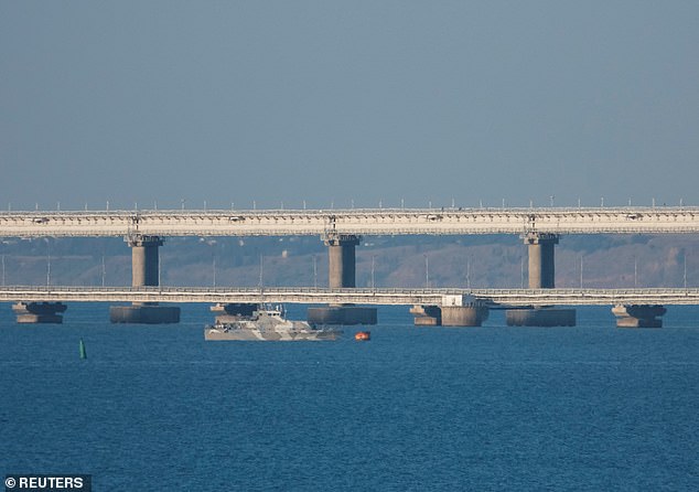 An armed ship sails next to Crimean bridge connecting the Russian mainland with the peninsula across the Kerch Strait, Crimea on Monday