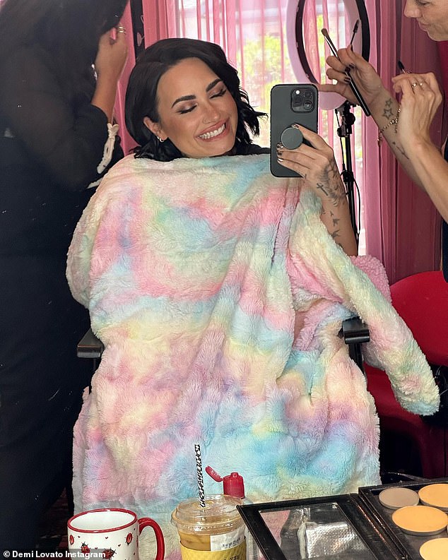 BTS: Lovato bedeckte sich mit einem Bademantel mit Batikmuster, während sie sich frisieren und schminken ließ