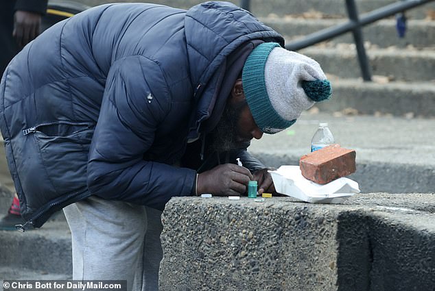 Ein Drogenkonsument bereitet sich darauf vor, am Straßenrand in Philadelphia zu schießen