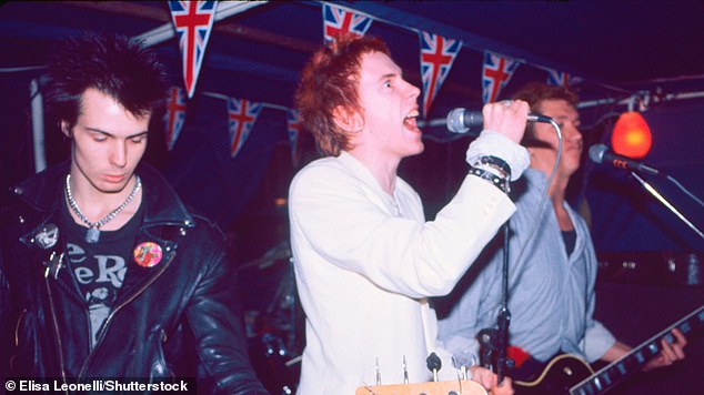 John Lydon alias Jonny Rotten (Mitte) tritt 1977 mit seinen Sex Pistols-Kollegen Sid Vicious (links) und Paul Cook (rechts) in London auf