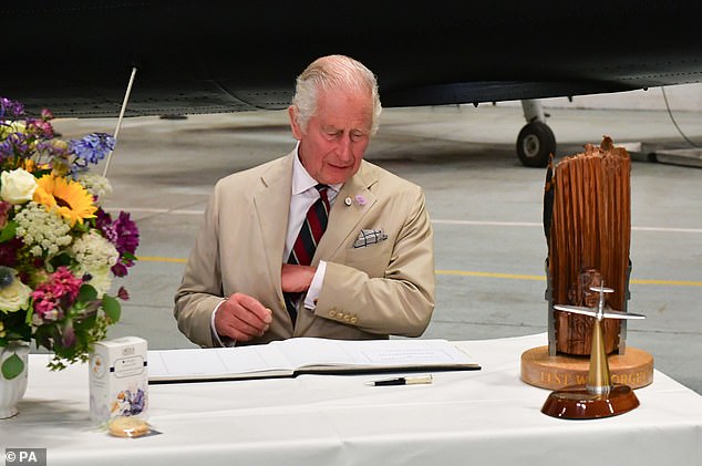 King Charles signs the visitors book during a visit to the Battle of Britain Memorial Flight in Coningsby, Lincolnshire