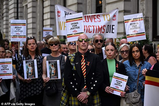 Demonstrators hold placards picturing victims and reading message related to the NHS infected blood scandal as Britain's Prime Minister Rishi Sunak is questioned by Inflected Blood inquiry, in London, on July 26, 2023
