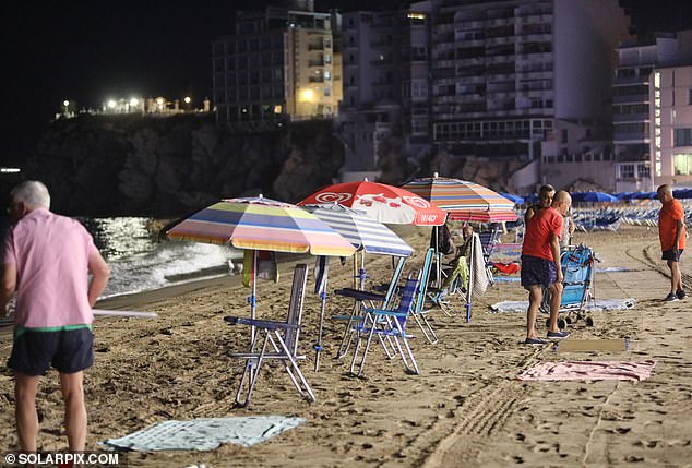 The beach is lined with parasols and deckchairs as competitive locals set up for the next day