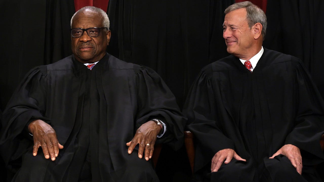 United States Supreme Court Associate Justice Clarence Thomas (L) and Chief Justice of the United States John Roberts (R)