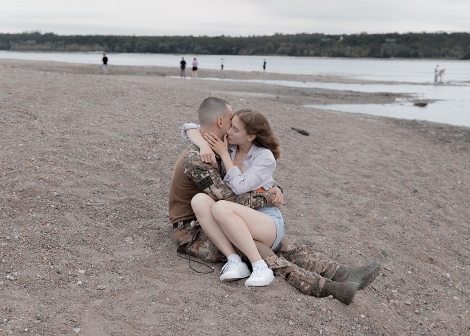 A couple embrace on a rocky beach